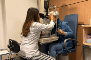 Paciente com pálpebra caída devido à miastenia ocular, avaliando sintomas visuais.
